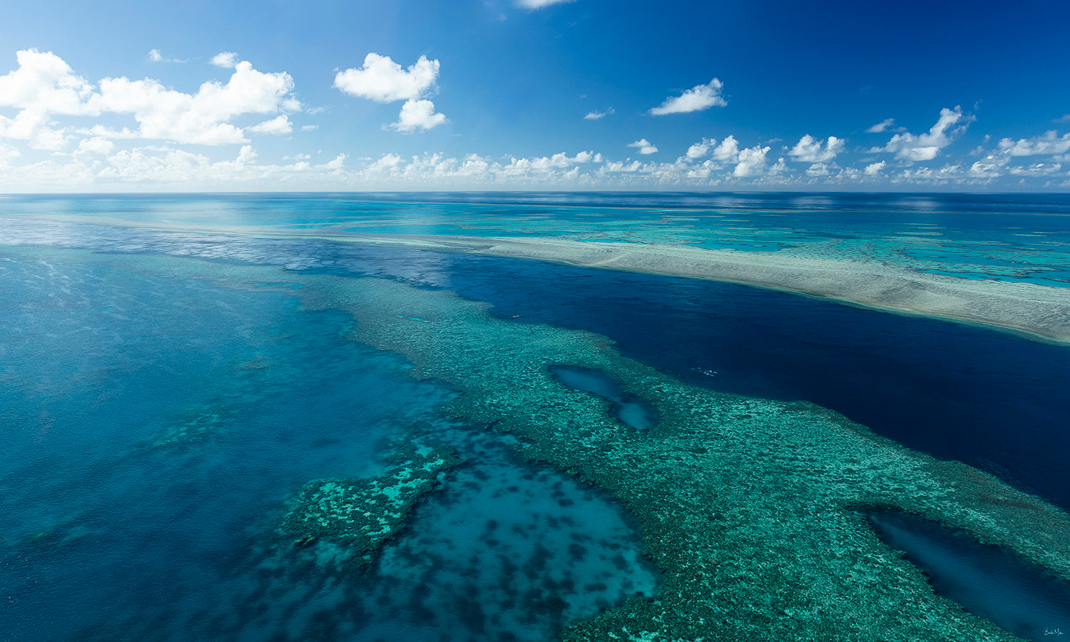 aerial shot of blue ocean water with a dark blue deep channel of water flowing