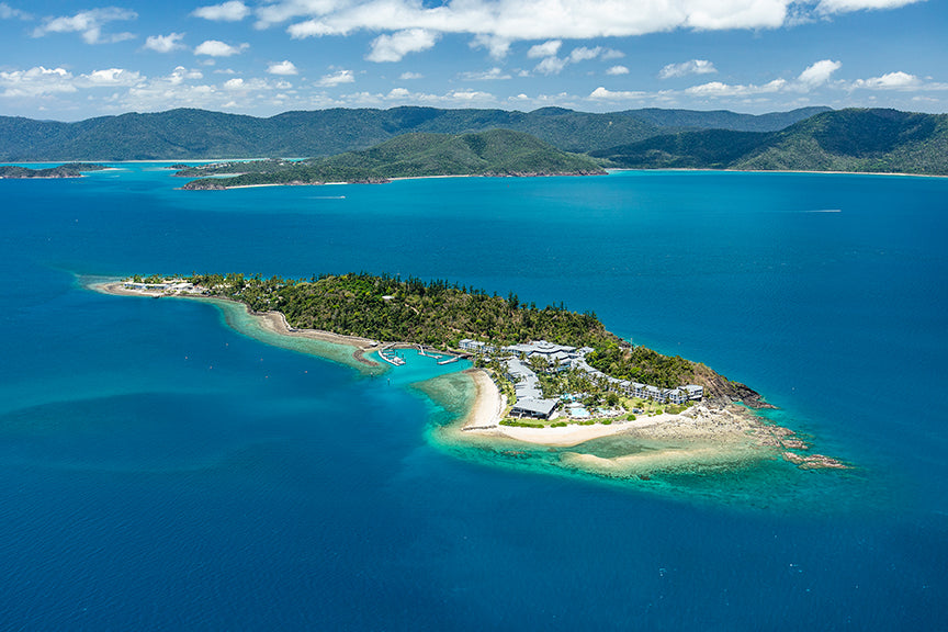 a holiday island with marina surrounded by blue water and other islands