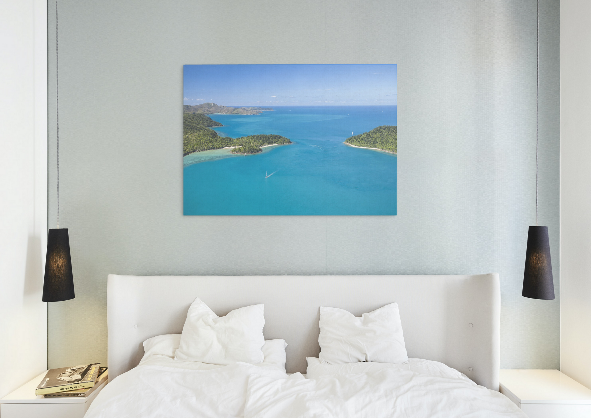 sailboat sailing between two islands as fringing reef hugs the coast line