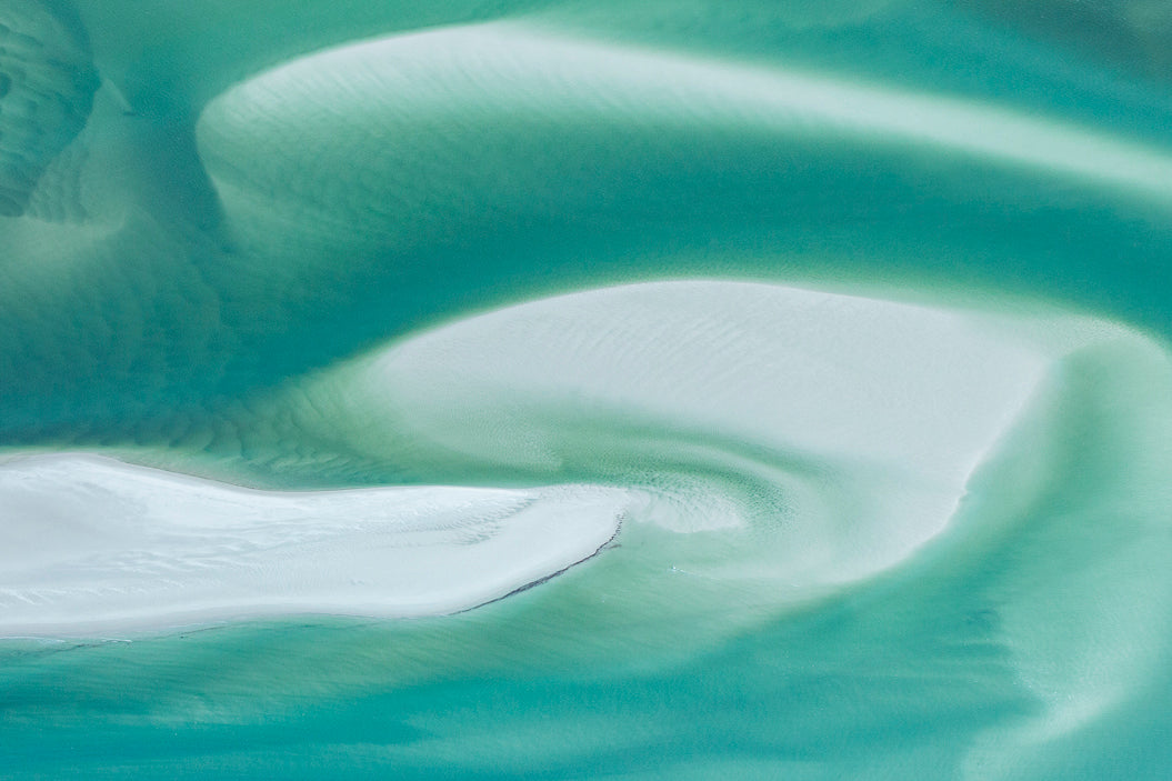 white silica sand amongst turquiose swirling water
