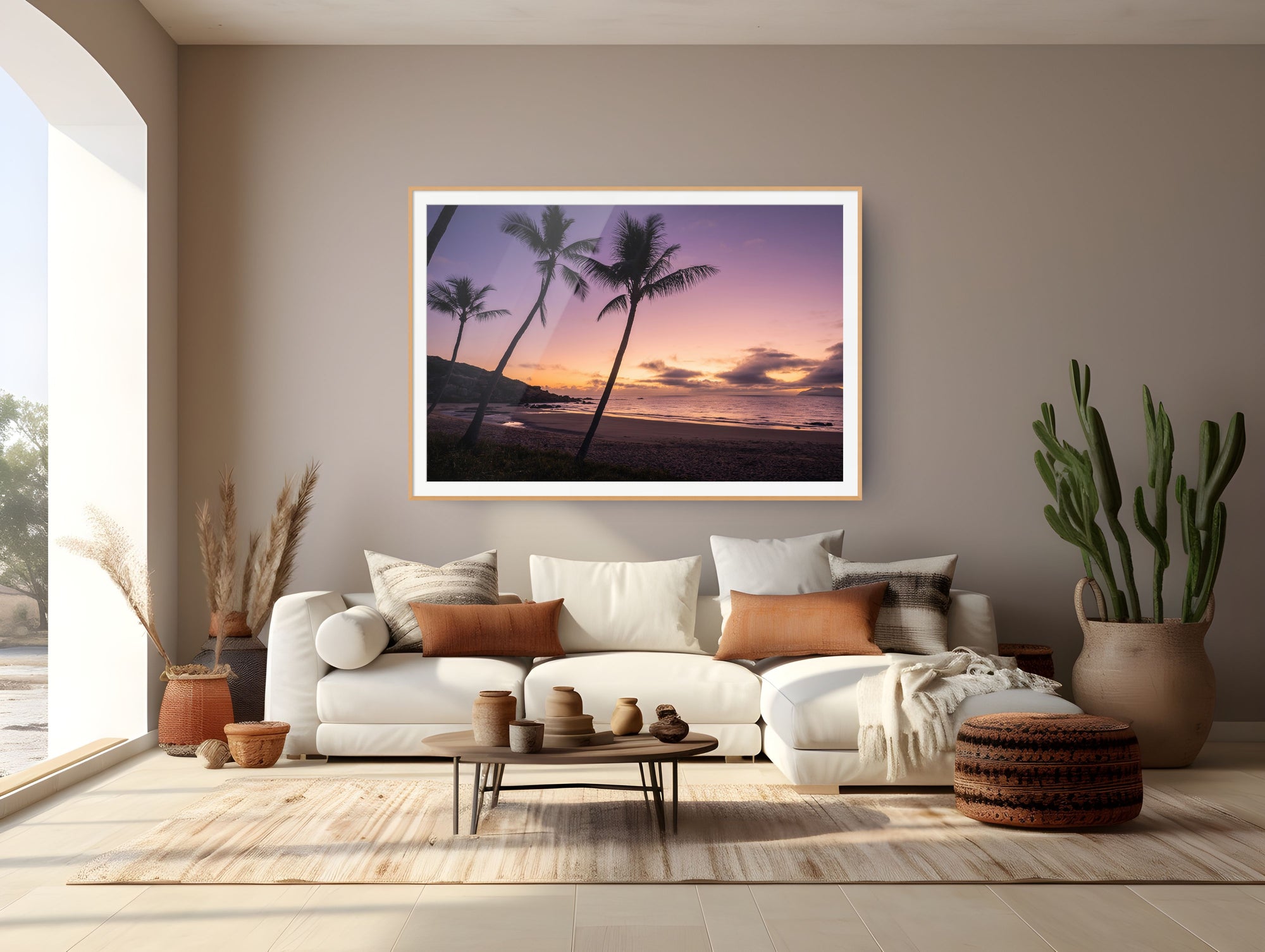 A framed wall art print depicting a tropical beach sunset with palm trees, displayed in a modern living room setting above a white sectional sofa.