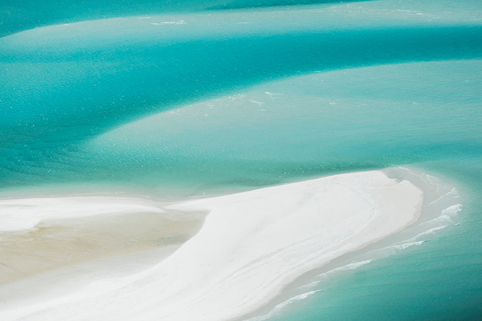 large white sand bar and turquiose waters swirling around it