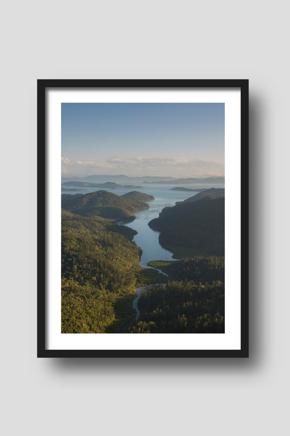 afternoon light setting over the hills of an island with a passage of water running down the middle