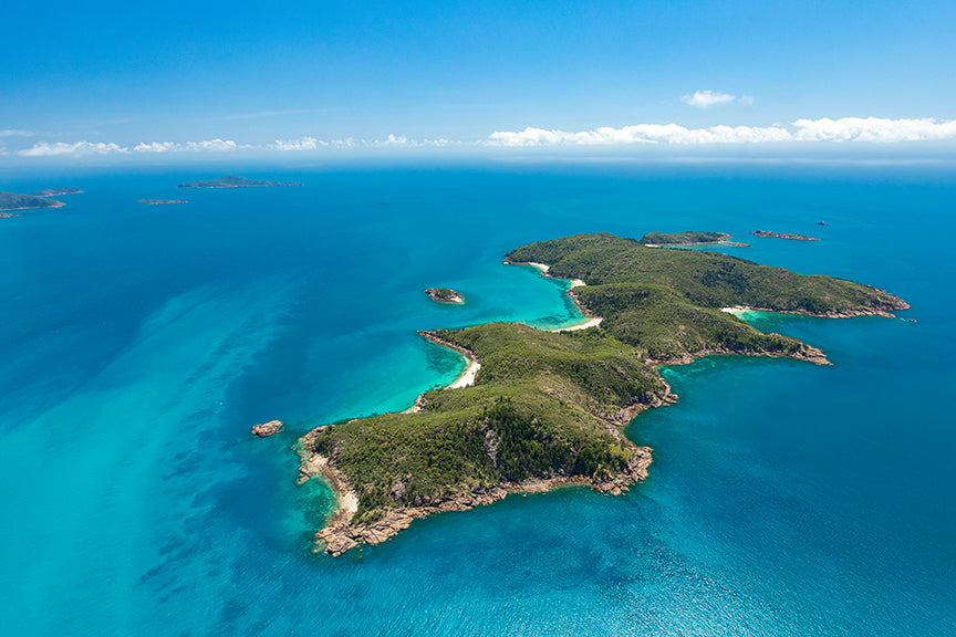 aerial of island with surrounding beaches and reef