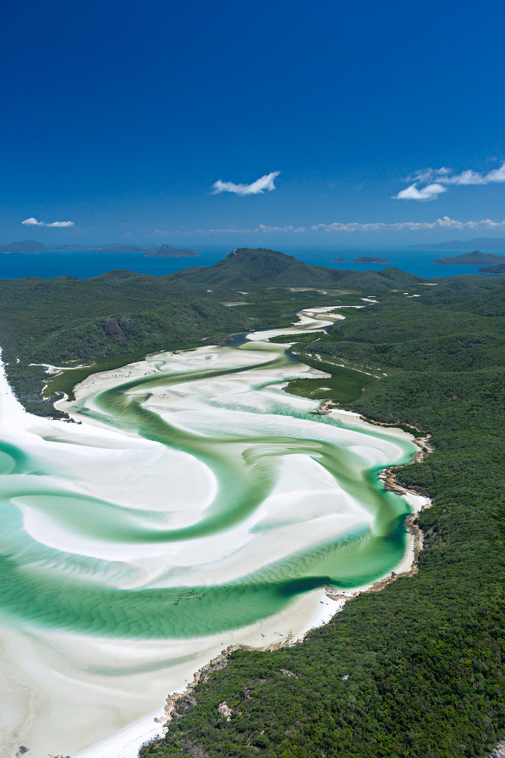 white silica sand swirling between 2 islands of green hills