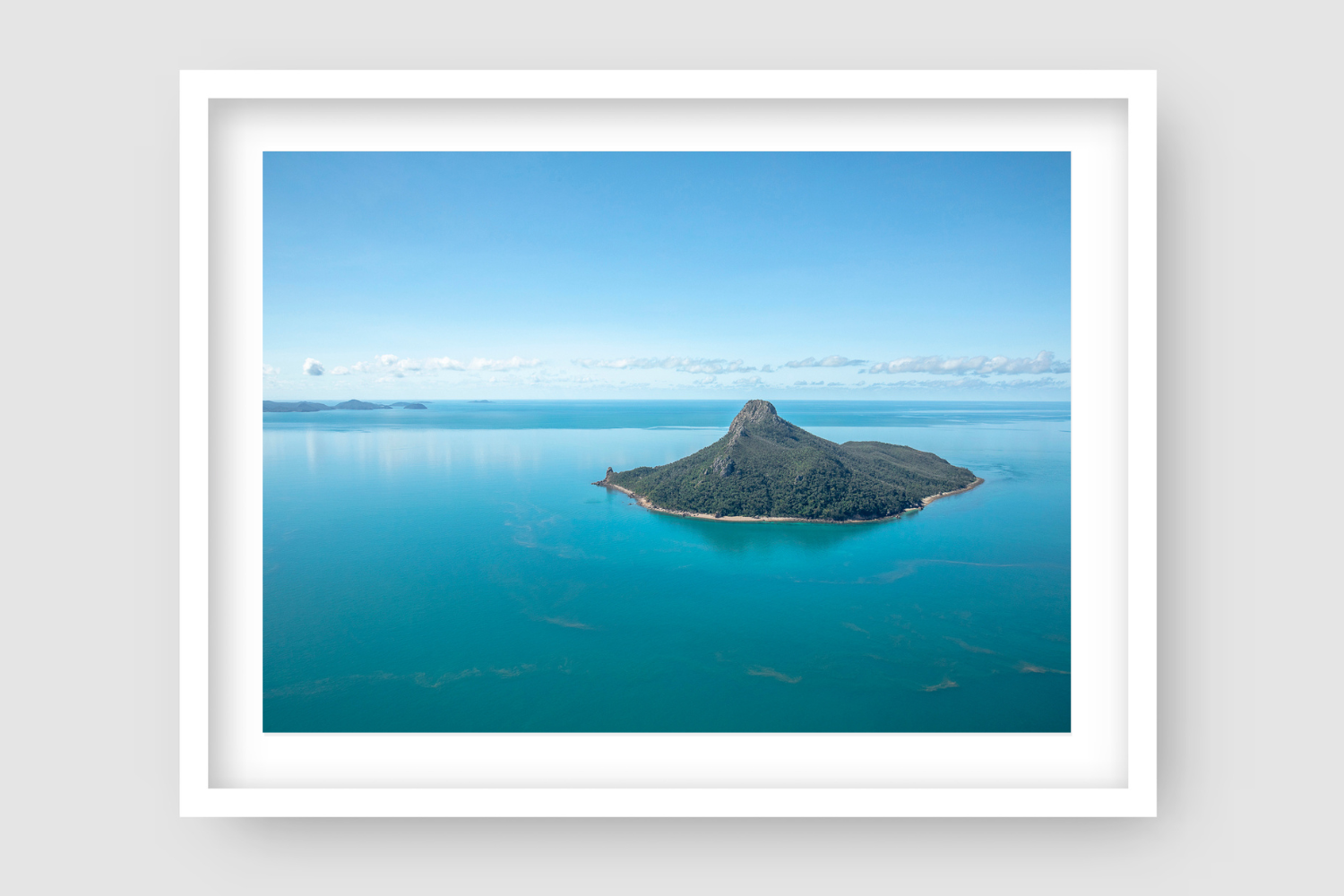 flat calm blue ocean waters surrounding a tall mountainous island