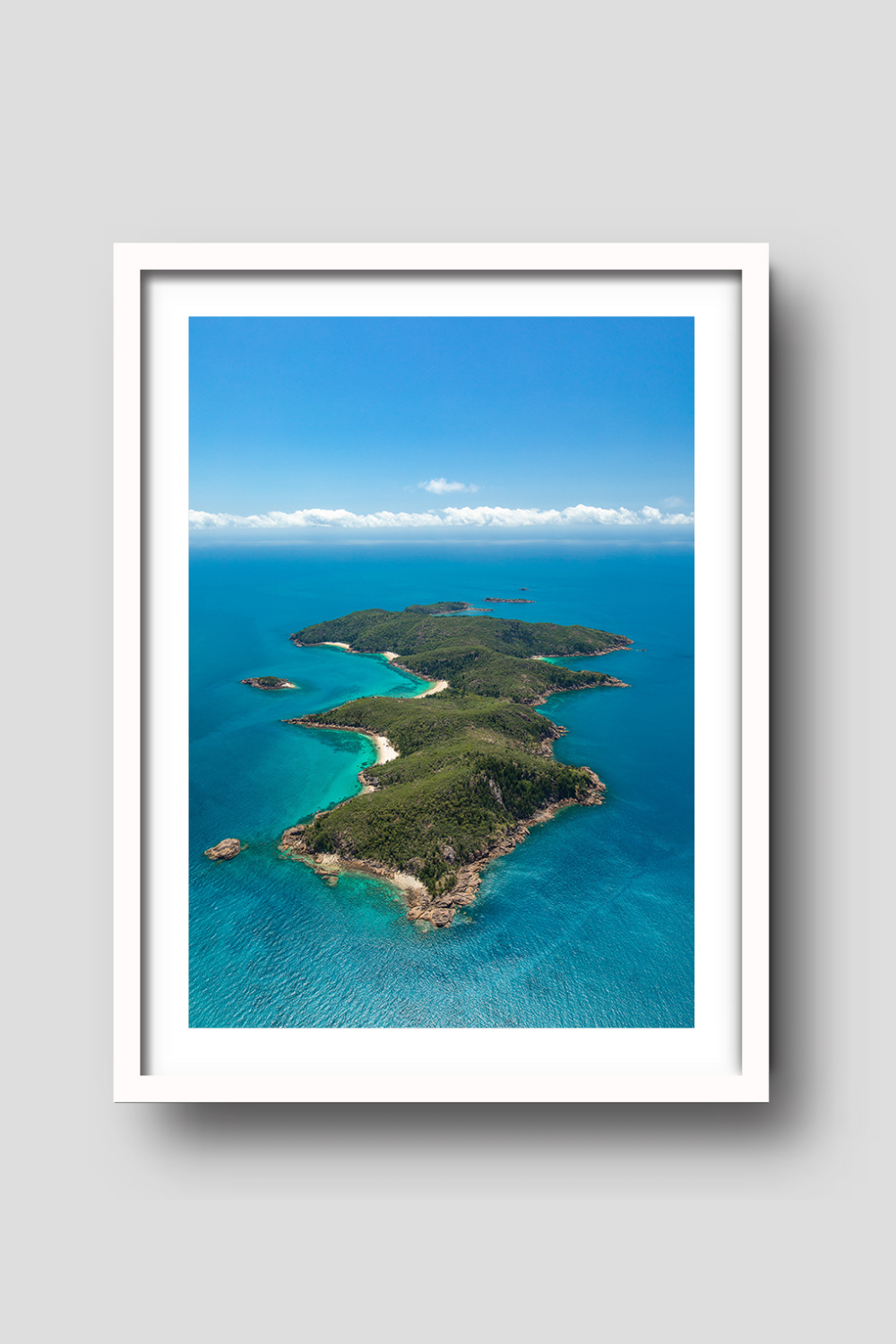aerial of island with secluded white sandy bay and blue ocean surrounding