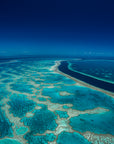 far and wide coral reef in blue and green colours with deep channel of water 