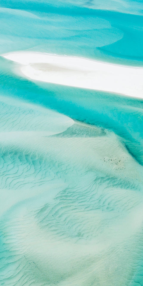 turquoise water swirling and rippling amongst white sands